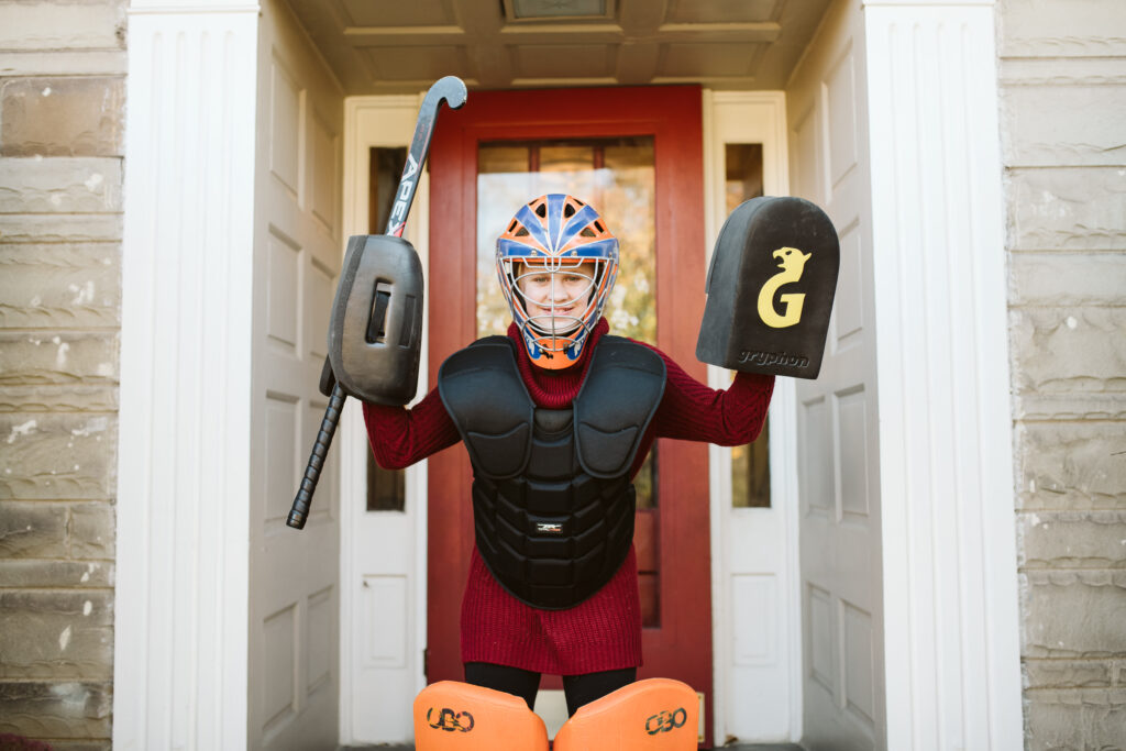 Teenager dressed in field hockey goalie uniform
