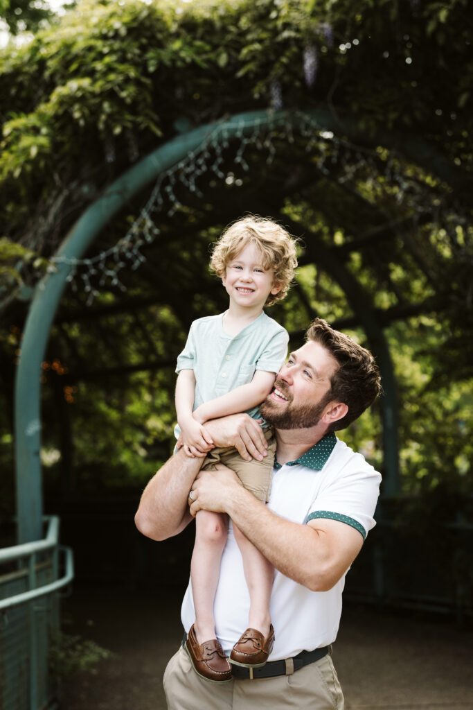 portrait of father holding son on shoulder