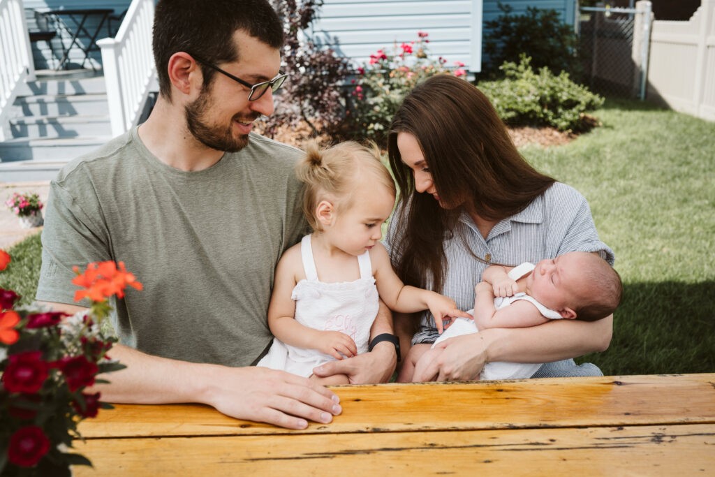 family holding children outside during newborn lifestyle session