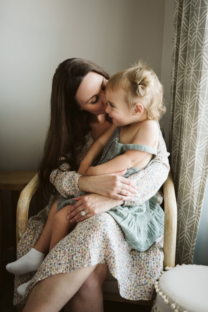 mother holding daughter during newborn lifestyle session