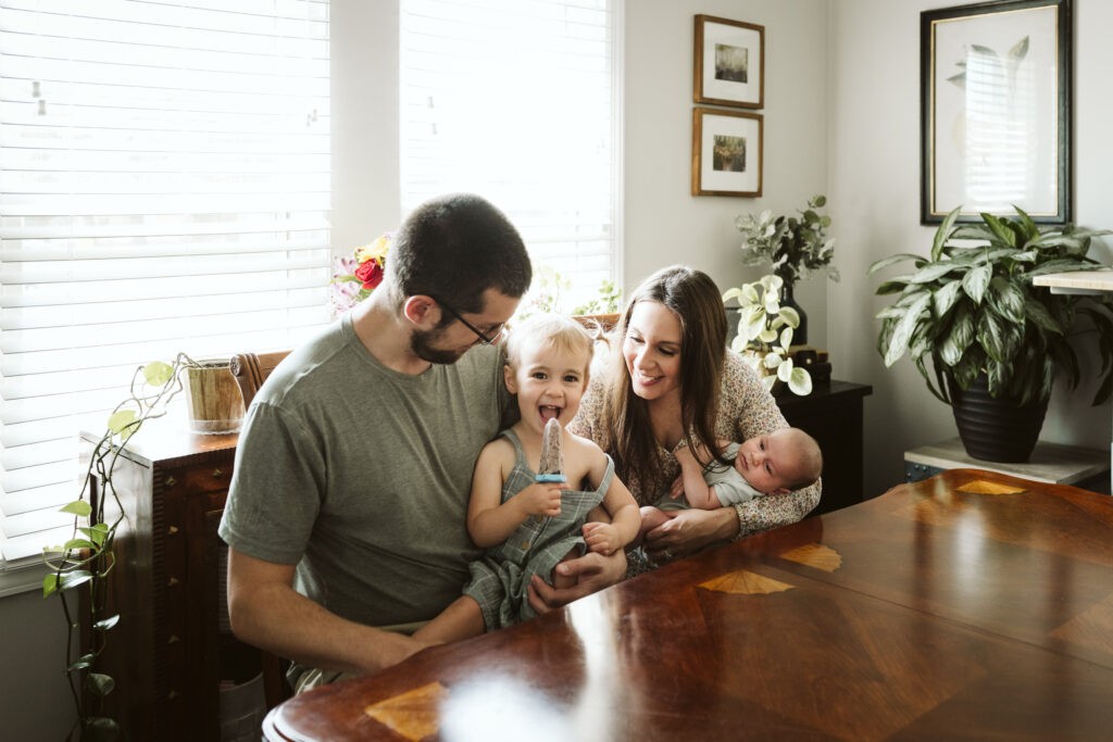 family holding children eating popsicles during newborn lifestyle session