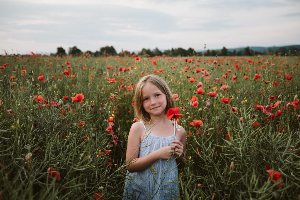 girl in a poppy field at sunset