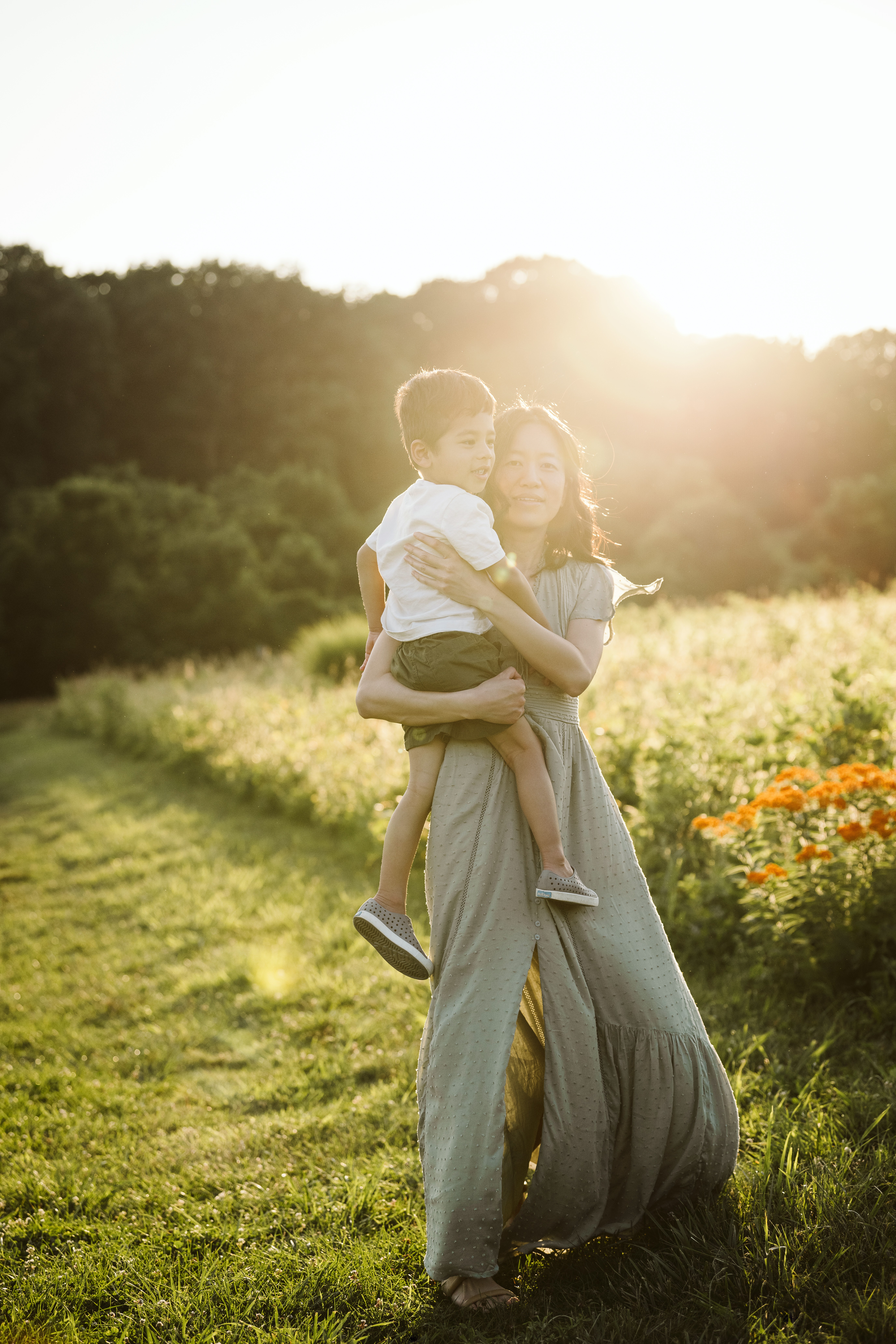 mother and son posing for a portrait in a rural field with a sun flare near Pittsburgh, PA