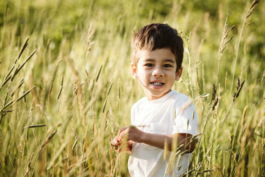 young child playing during a portrait in a rural field near Pittsburgh, PA