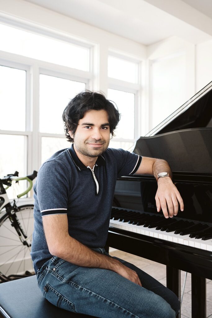 editorial portrait of man sitting at a grand piano