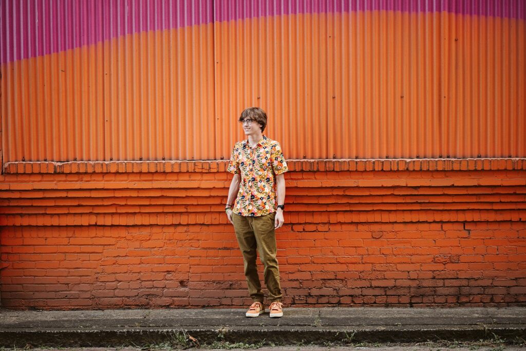 senior portrait with orange wall in Pittsburgh