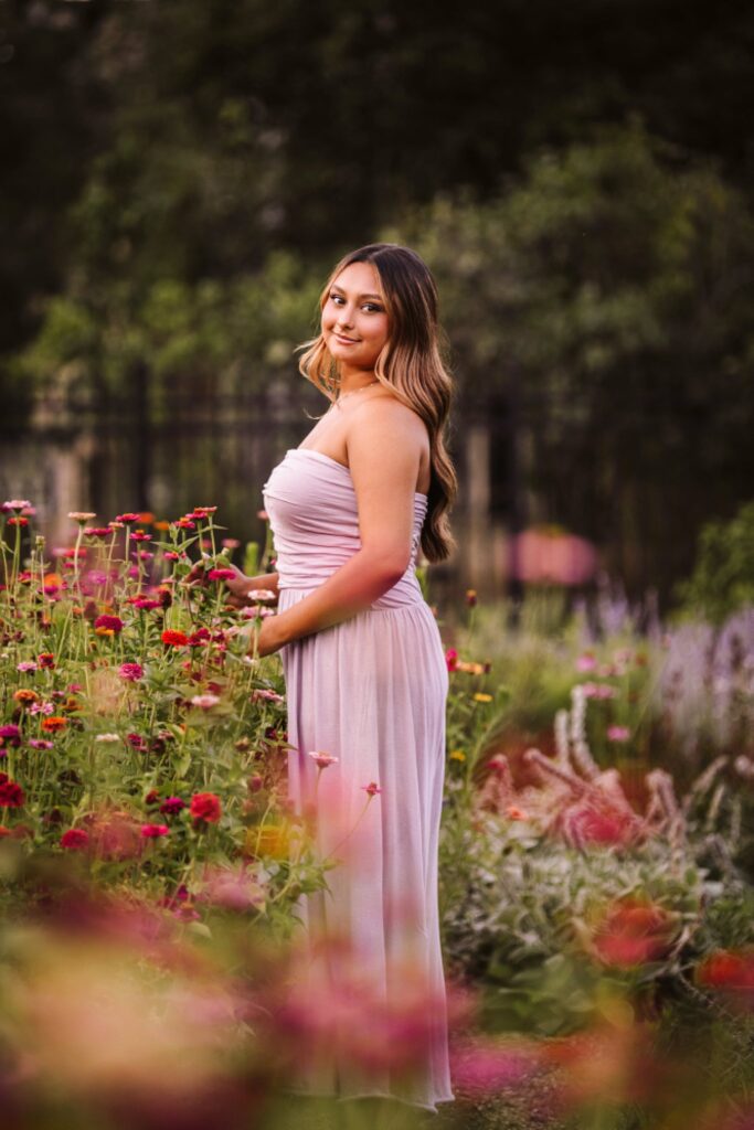 senior girl picture in colorful garden at sunset