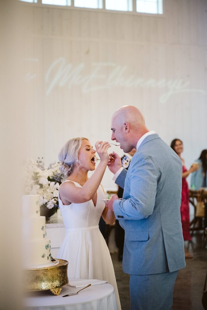 bride and groom feeding each other cake during reception at The Grayson House