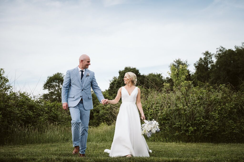 bride and groom walking near a forest