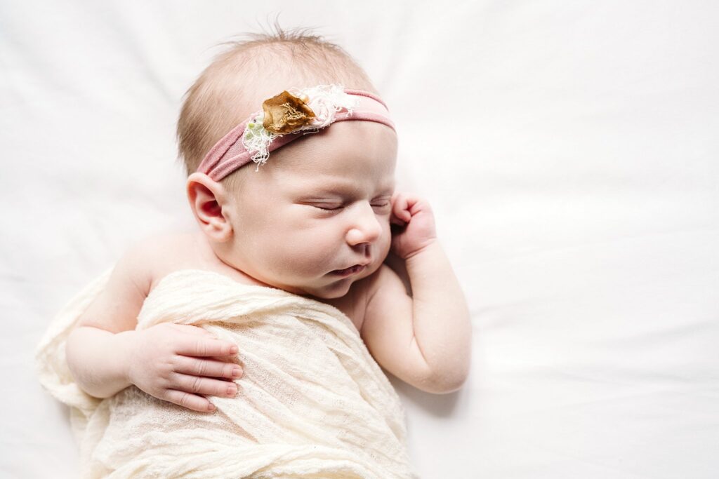 beautiful newborn baby sleeping on bed