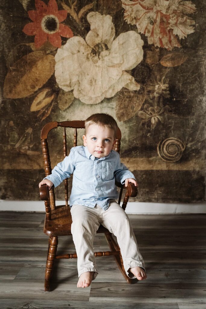 big brother rocking on chair during newborn photoshoot