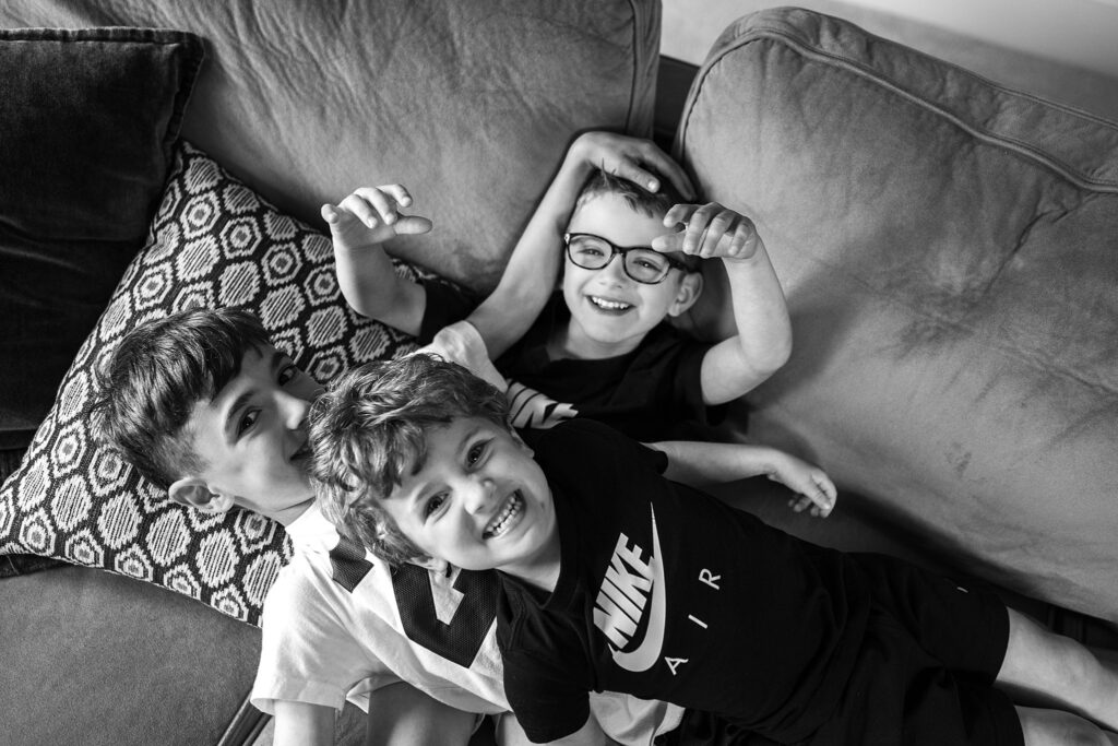 three boys laying on a sofa during a lifestyle photoshoot at home in Pittsburgh