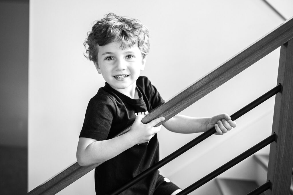 boy walking up stairs at home during a lifestyle photoshoot in Pittsburgh