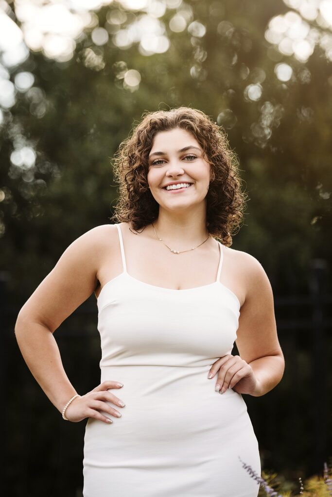 senior portrait in a flower garden at sunset