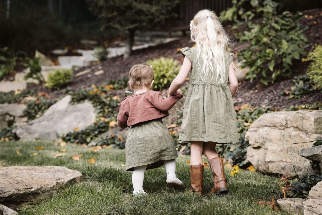 girls walking during extended family portrait captured in family's backyard