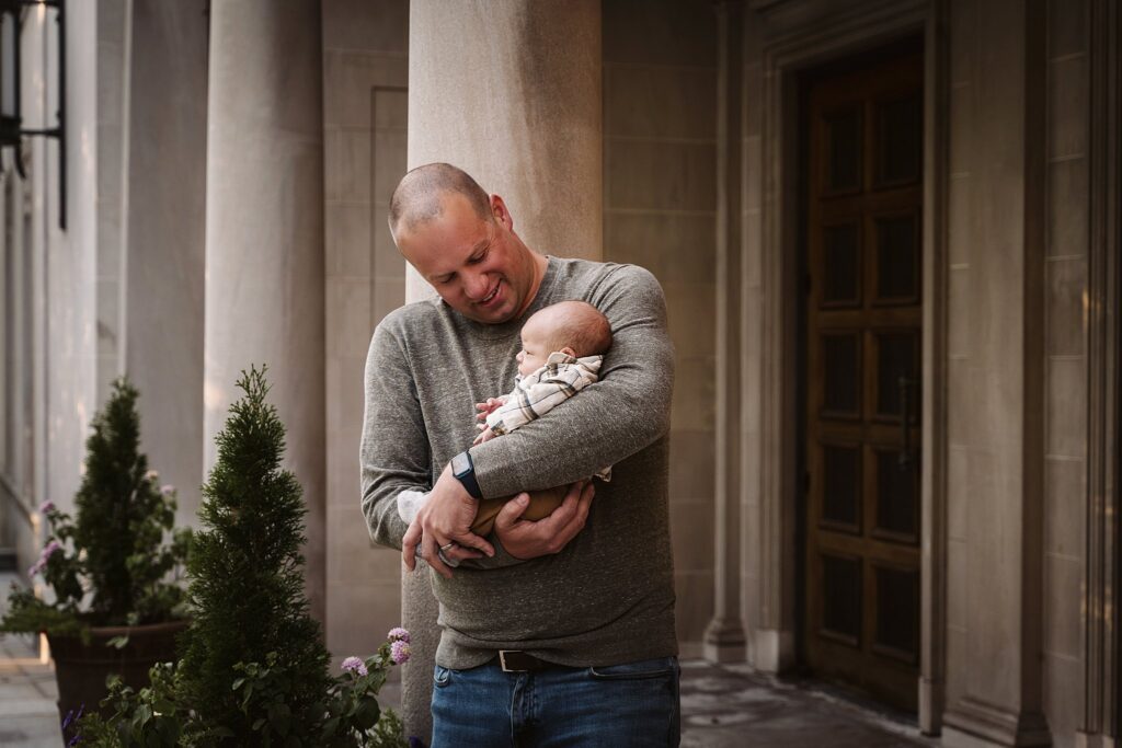 dad holding newborn son at family portrait