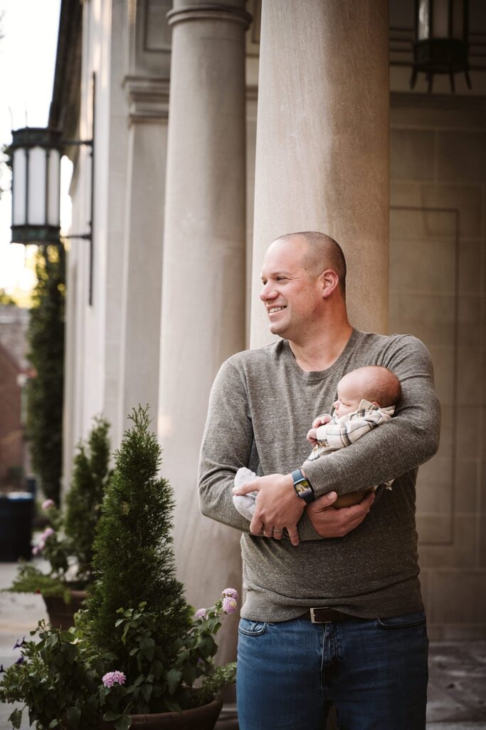 dad holding newborn son at family portrait