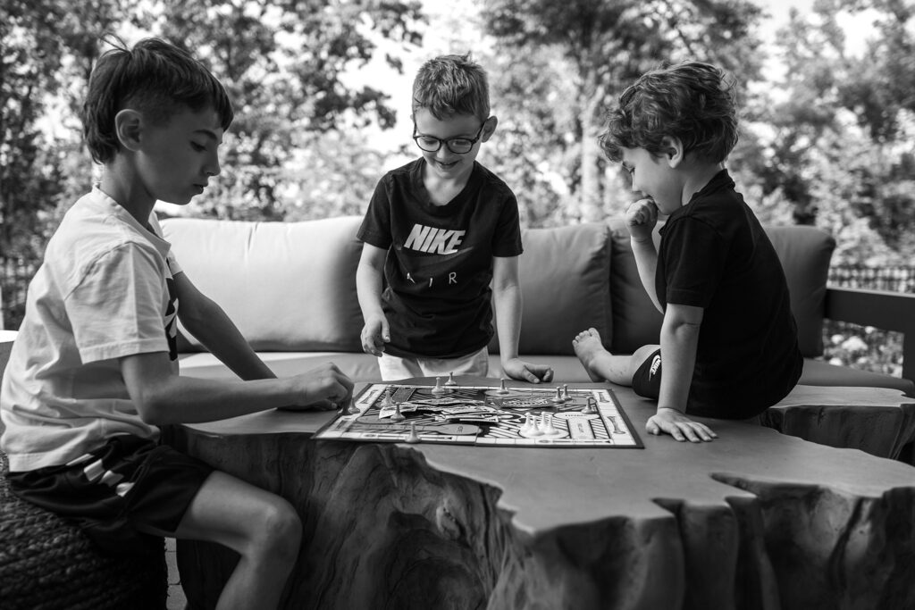 black and white lifestyle portrait of brothers playing a board game at home