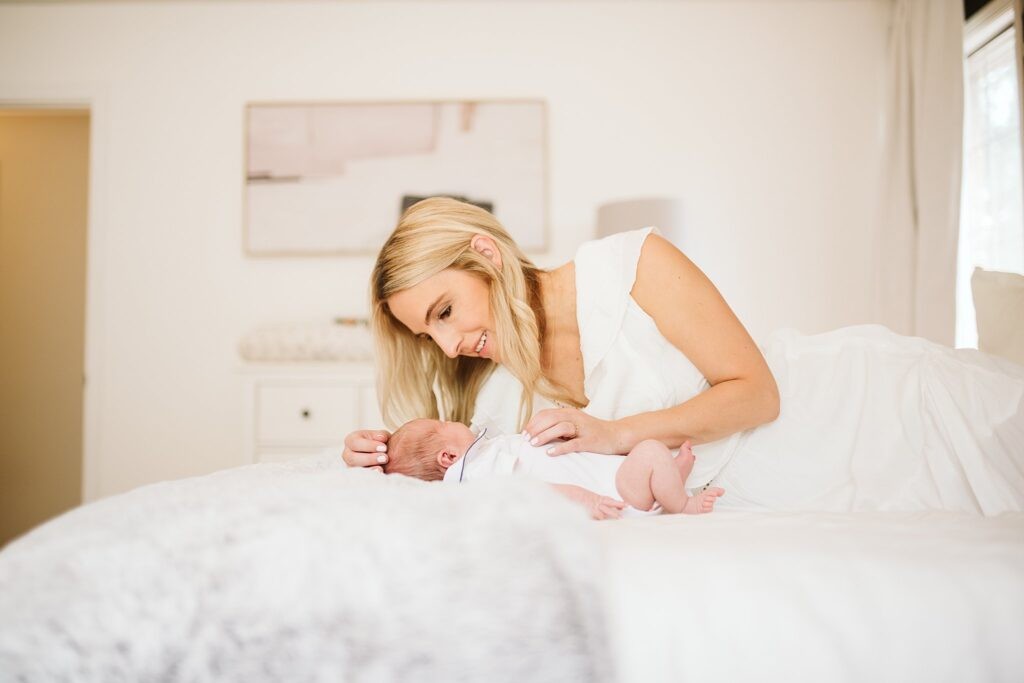 lifestyle portrait of a newborn with mom in a white room