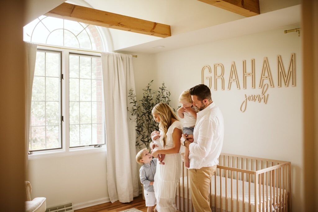 lifestyle portrait of a newborn with family in nursery