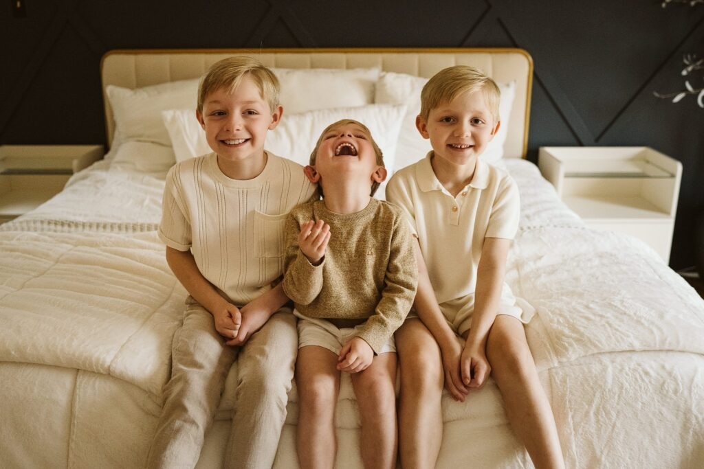 lifestyle portrait of brothers sitting on bed
