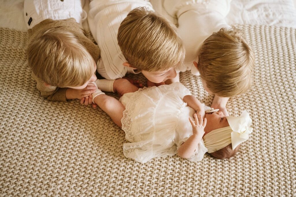 lifestyle portrait of siblings laying on bed