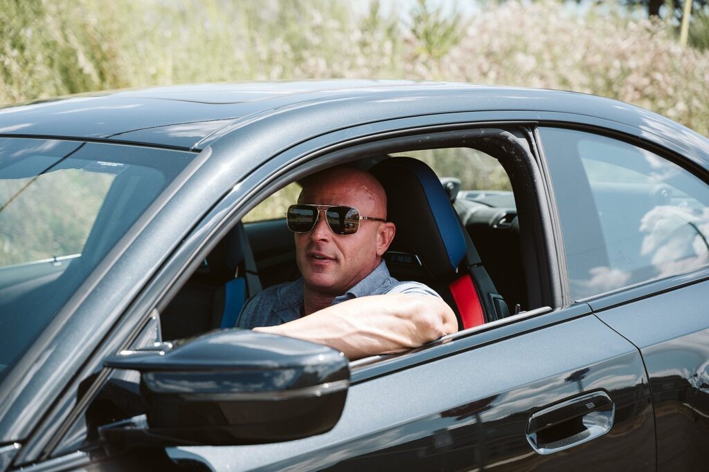 editorial portrait of man driving a car