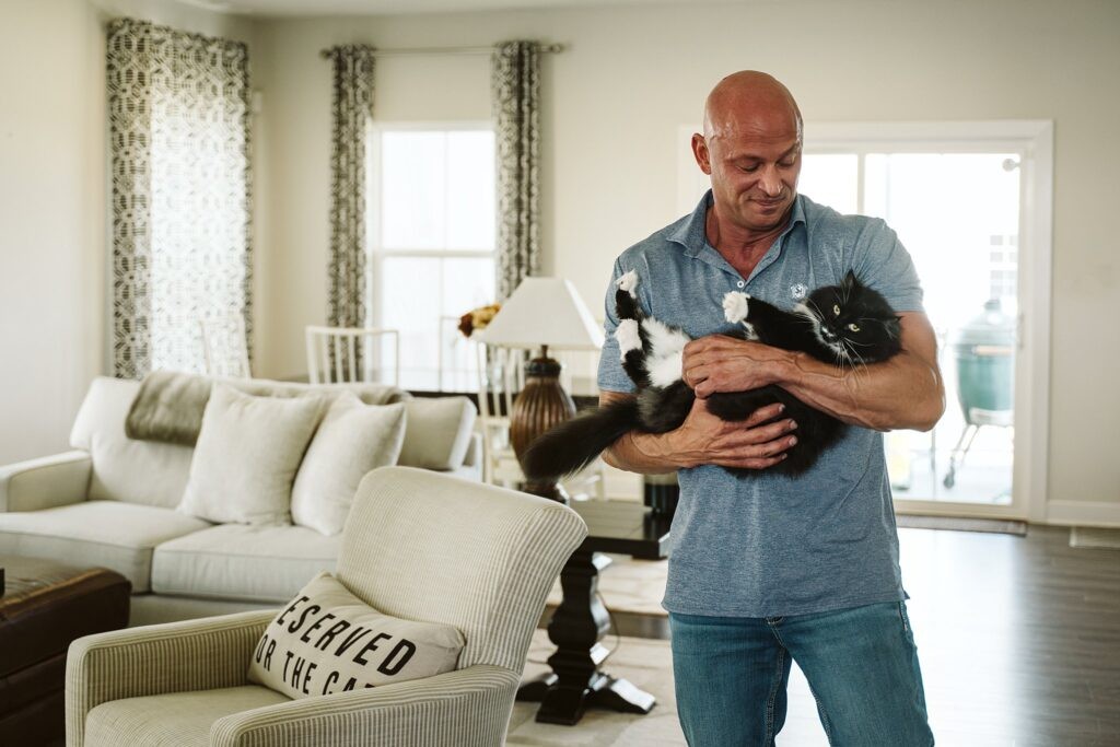 editorial portrait of man holding a cat