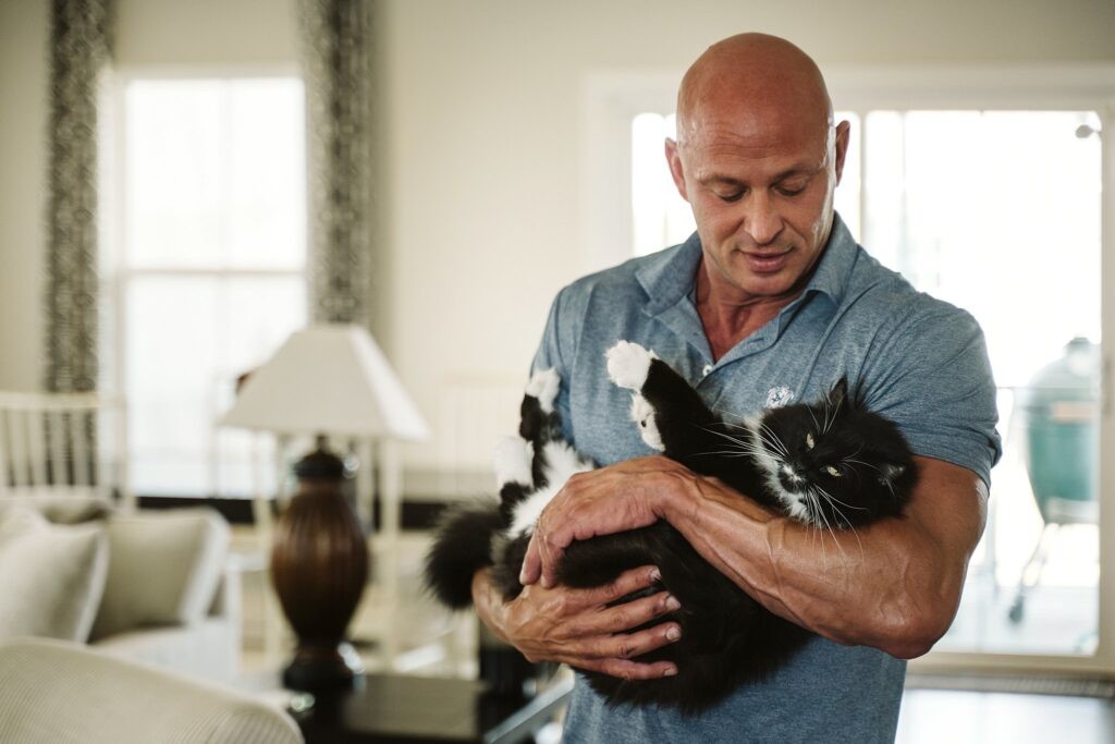 editorial portrait of man holding a cat