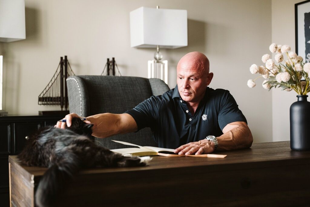 editorial portrait of man working at desk with cat
