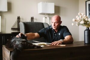 editorial portrait of man working at desk with cat