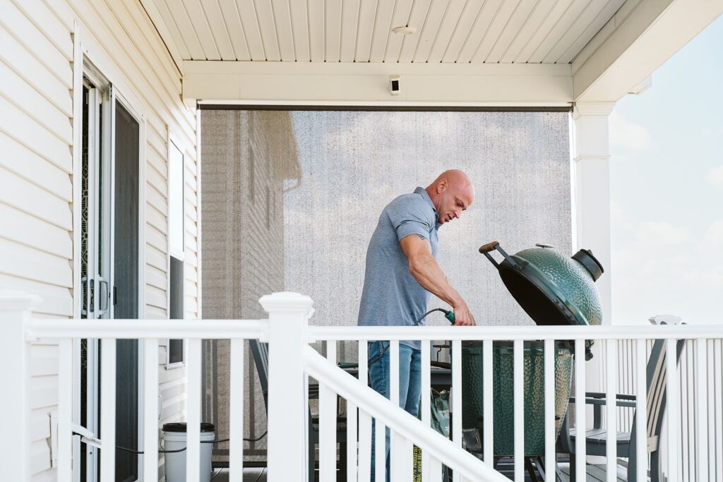 editorial portrait of man grilling outside