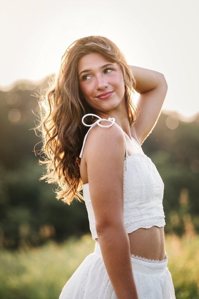 High school senior girl dancing in field during golden hour
