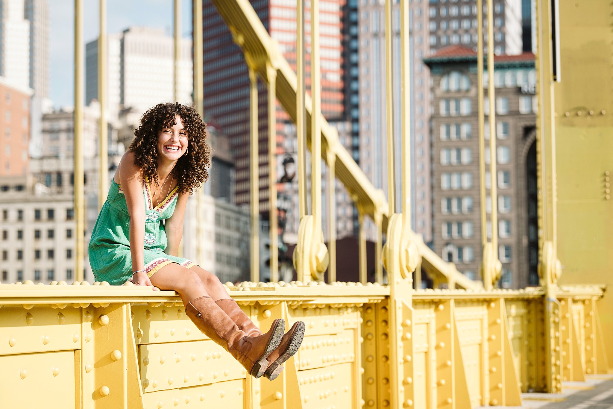 senior girl sitting on the Roberto Clemente Bridge in Pittsburgh