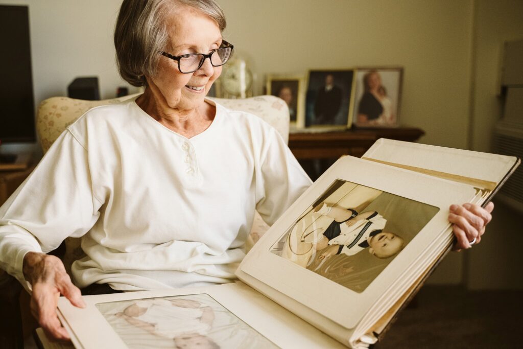 editorial photograph of senior woman at home with family photos