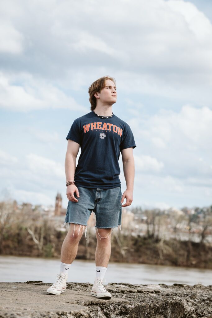 Artistic senior portraits for a guy at Washington’s Landing in Pittsburgh, featuring a relaxed style against the riverfront and boardwalk views.