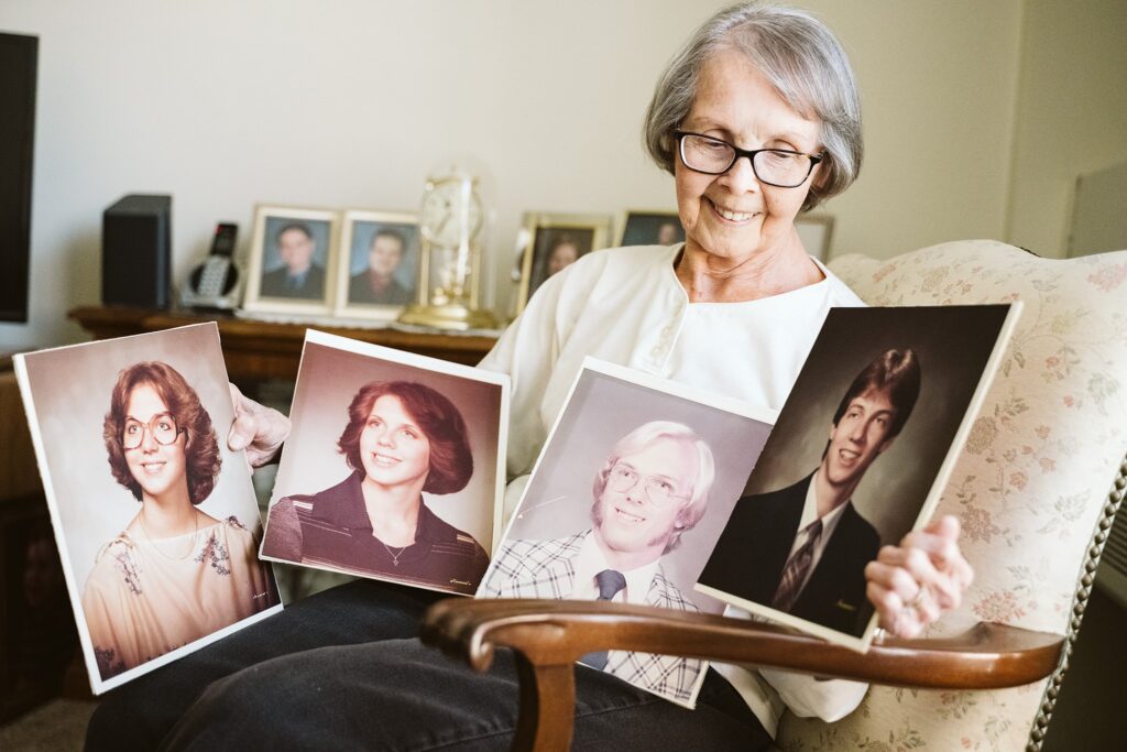 editorial photograph of senior woman at home with family photos