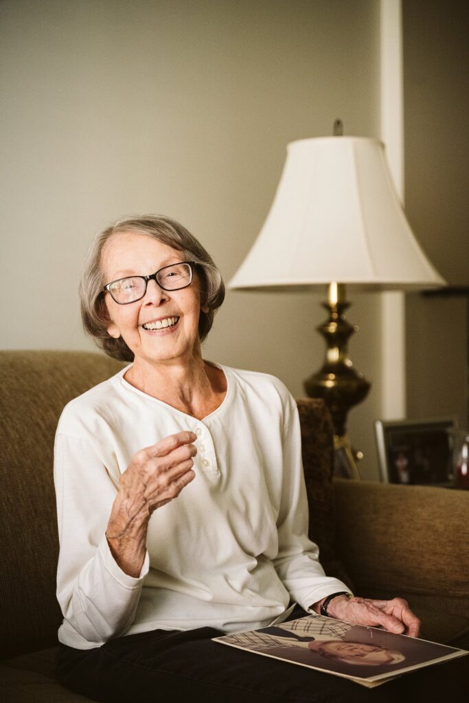editorial photograph of senior woman at home with family photos