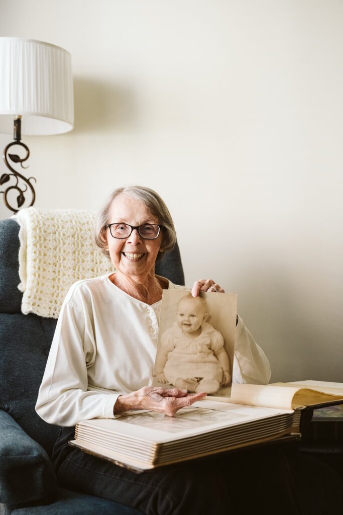 editorial photograph of senior woman at home with family photos
