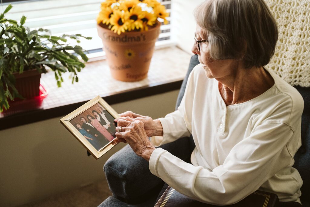 editorial photograph of senior woman at home with family photos