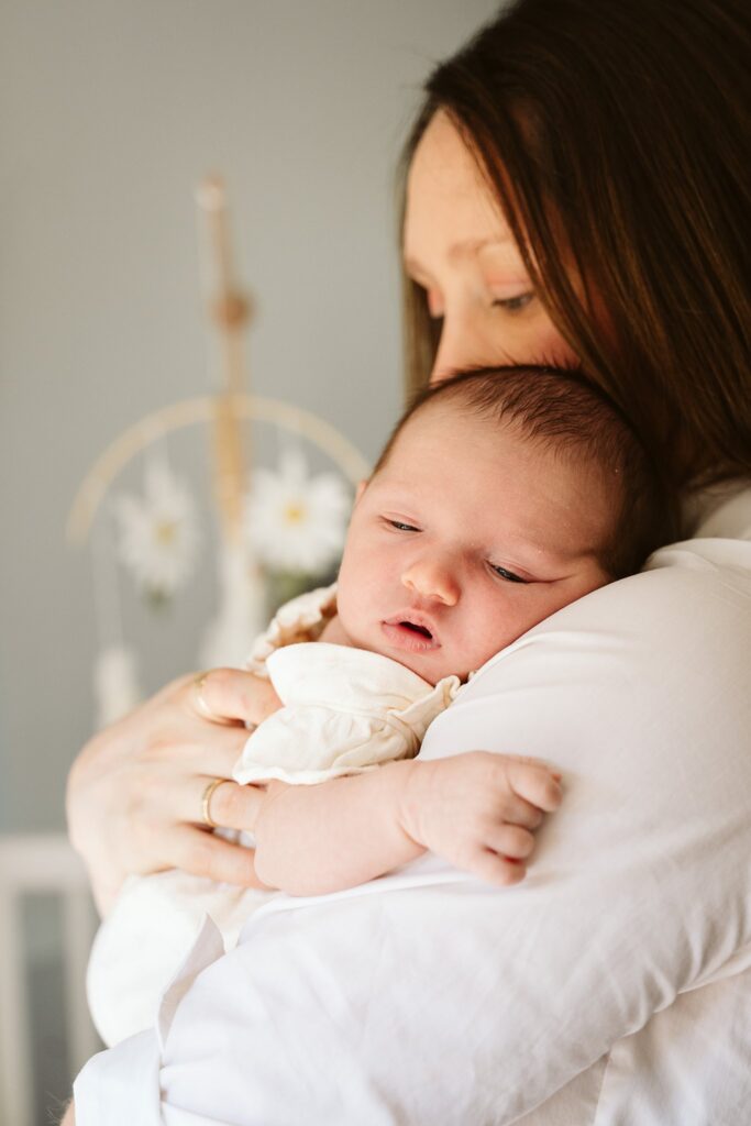 Mother holding her newborn baby at home