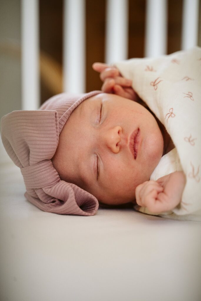 Newborn baby girl sleeping peacefully in her crib