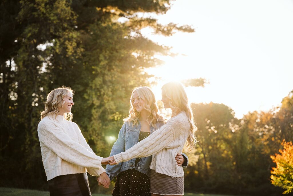 Mother holding hands with her daughters during a family photography session in a Pittsburgh park