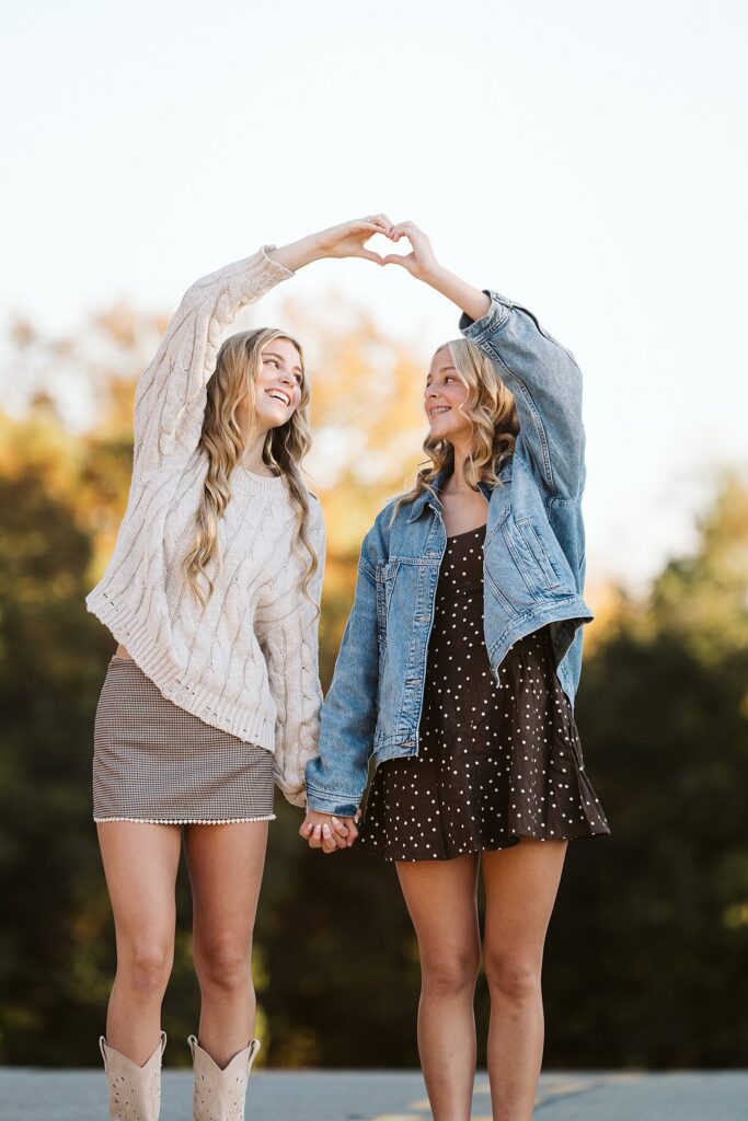 close up shot of two sisters making a heart with their hands in beautiful natural light during a Pittsburgh family photography session