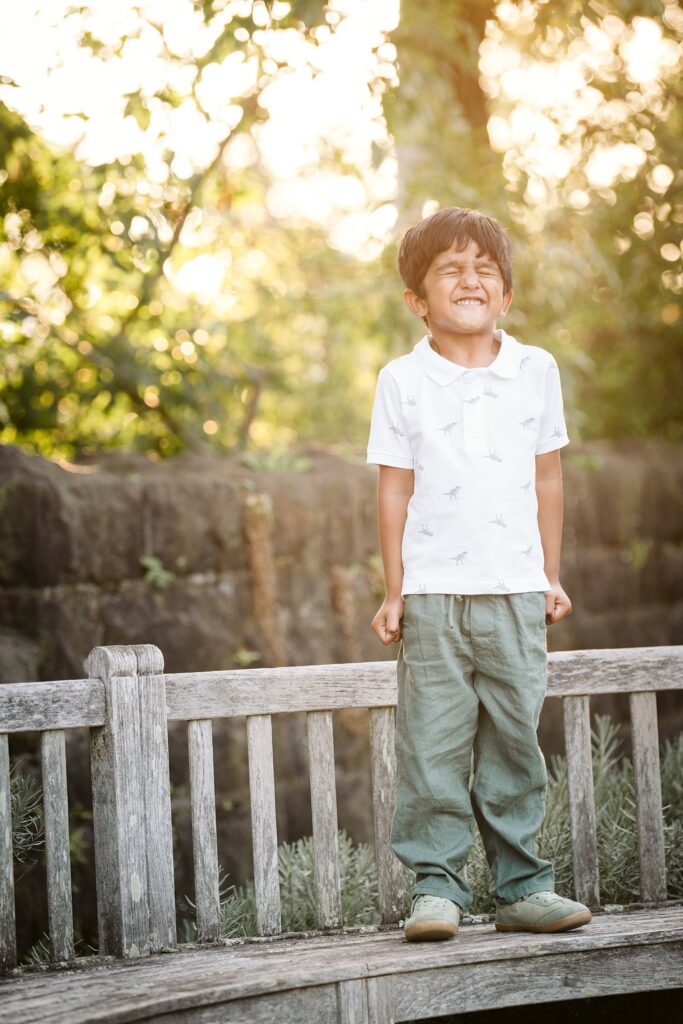 young boy standing on a bench