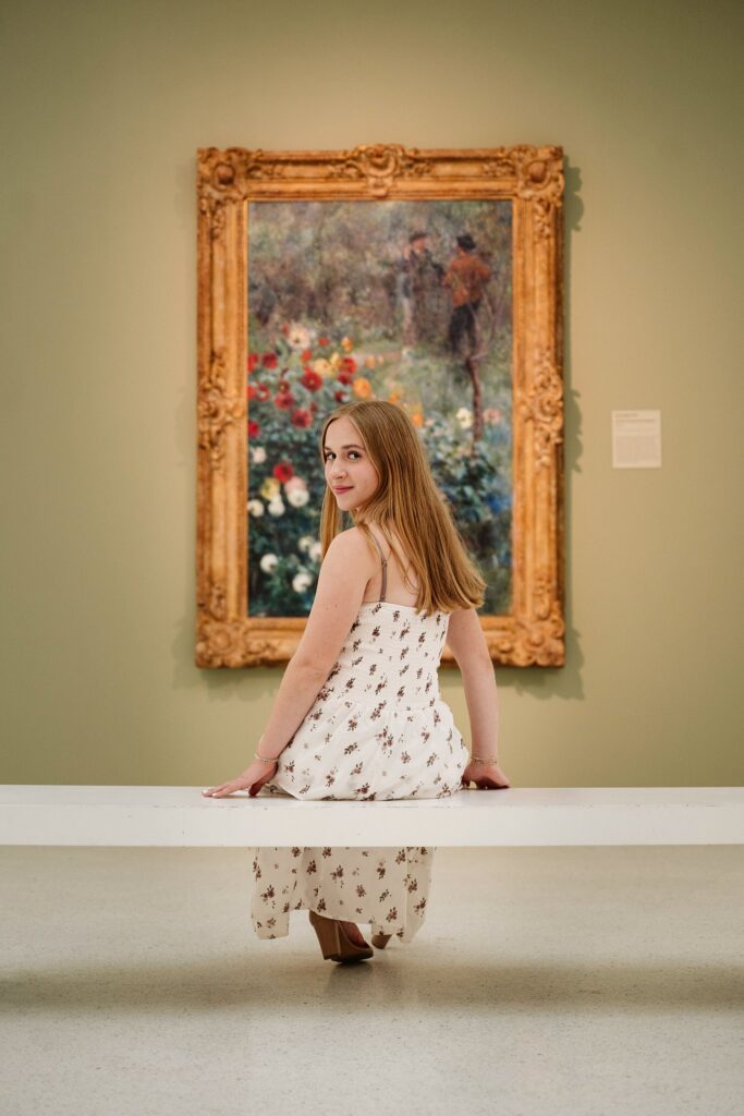 senior girl sitting in front of artwork at Carnegie Museum of Art
