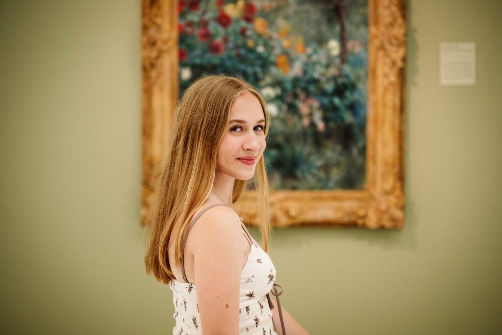senior girl sitting in front of artwork at Carnegie Museum of Art
